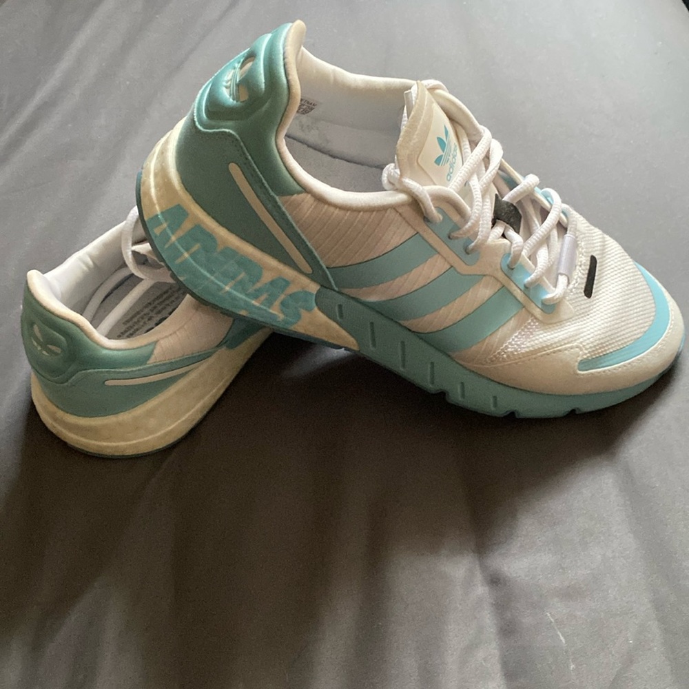 Women’s light blue and white Adidas ZX 1K athletic shoes.